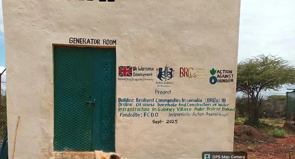 A generator room door inside a borehole compound, marked with the project name that built it.